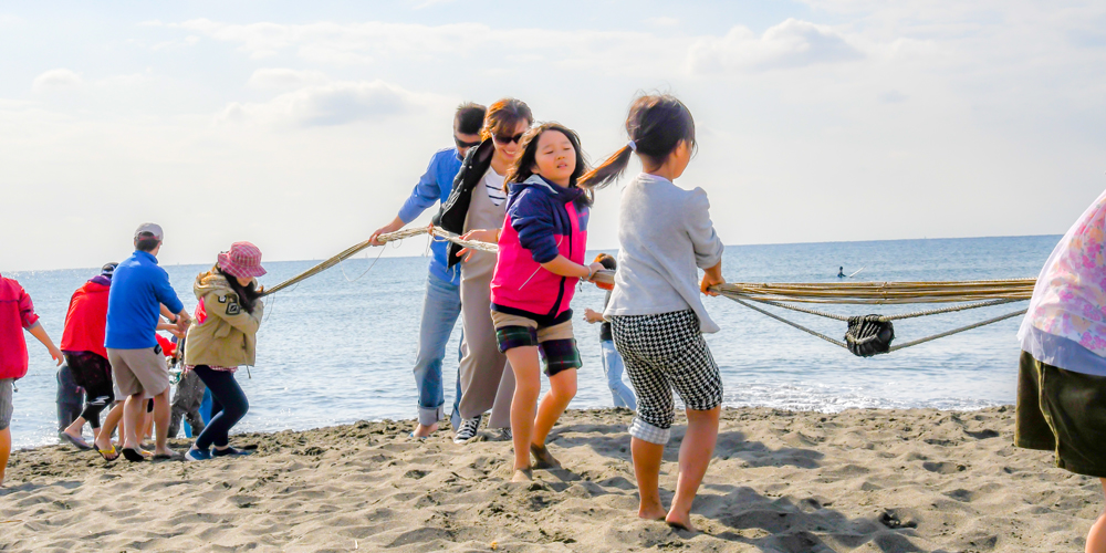 瀬戸内海の離島、小豆島の漁業体験で網を引く親子。